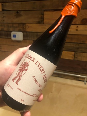 Under Every Deep A Lower Deep Opens Barleywine aged in Peach Brandy Barrels